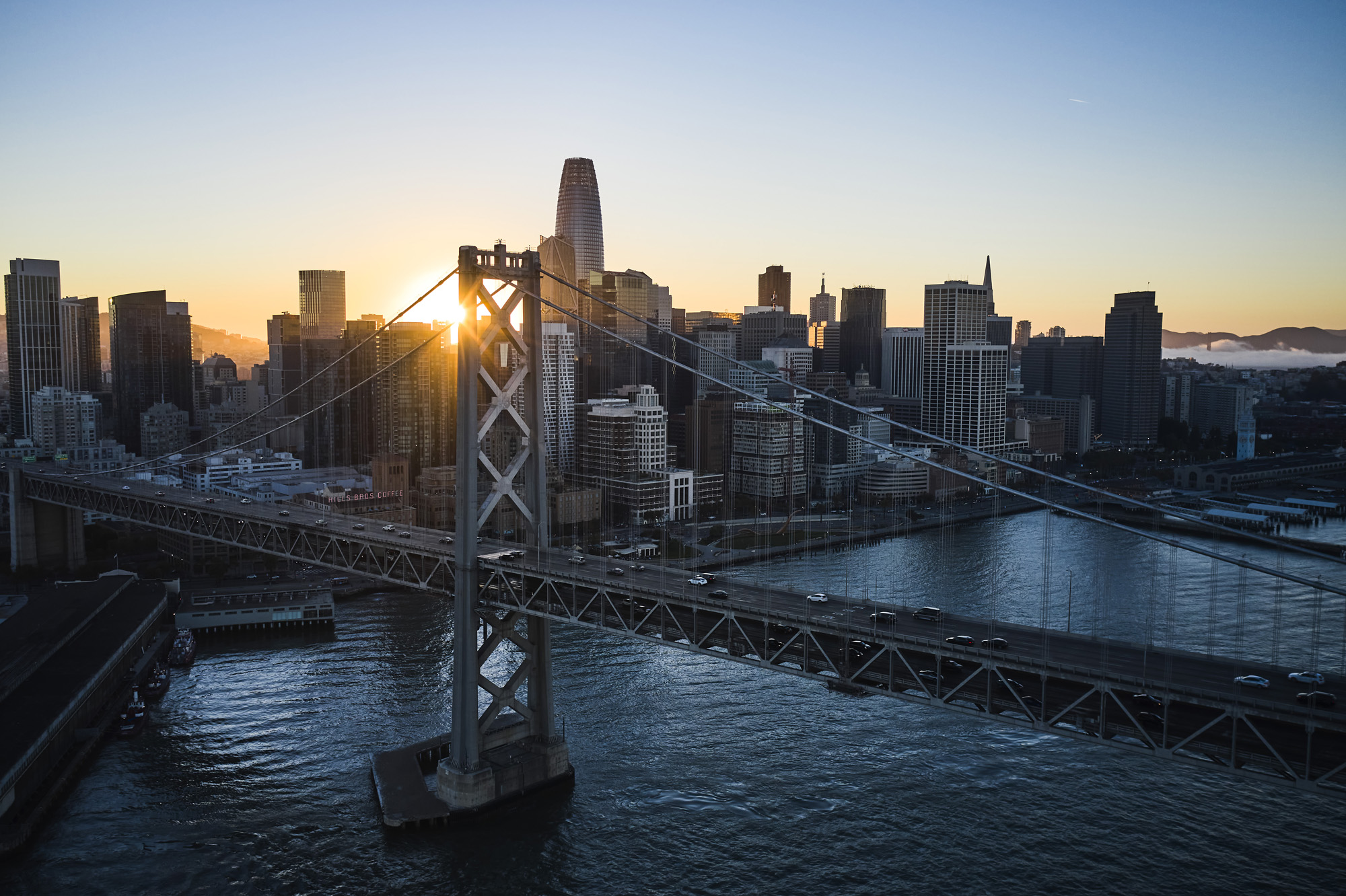 Drone photography image of sunset over the Bay Bridge with San Francisco in the background 